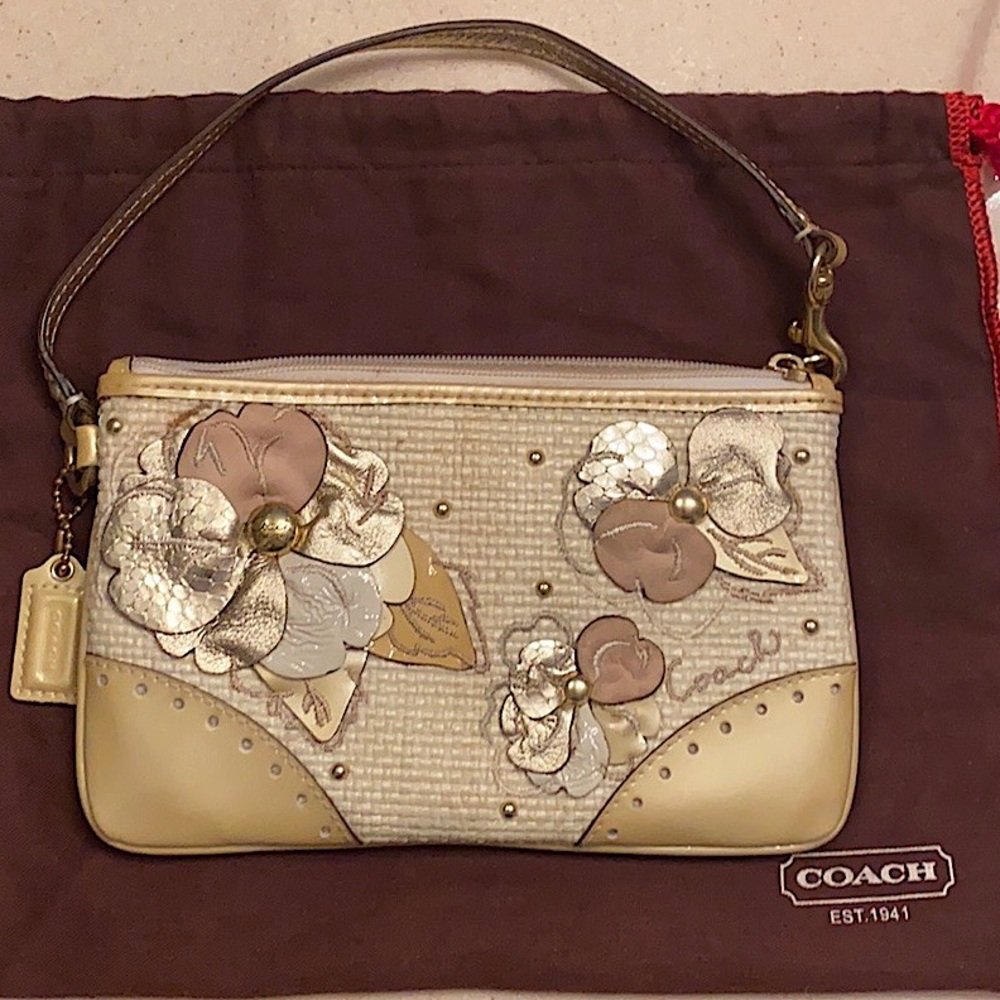 Off white Coach wristlet with flower details.